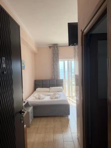 a small bedroom with a bed and a window at Villa AlMar in Sarandë