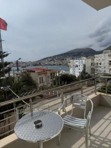 a table and chairs on a balcony with a view of a city at Villa AlMar in Sarandë