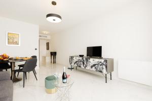 a living room with a television and a dining room at Gray d'Albion 3i7 YourHostHelper in Cannes