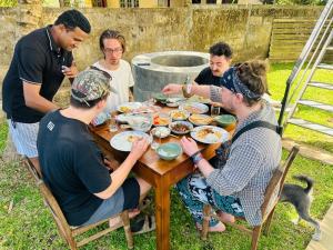 a group of people sitting around a table eating food at Zuulas Palace in Dickwella +37 photos