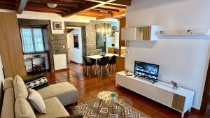 a living room with a couch and a tv in it at Retiro dos Biscoitos in Biscoitos
