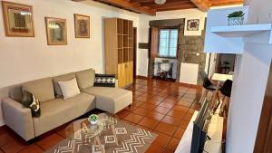 a living room with a couch and a glass table at Retiro dos Biscoitos in Biscoitos +13 photos