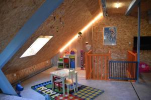 a attic room with a staircase and a room with a table at Domaine de Montauban in Perrancey