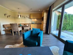 a living room with a blue chair and a table at Residenz Max mit eigenem Garten in Seefeld in Seefeld in Tirol