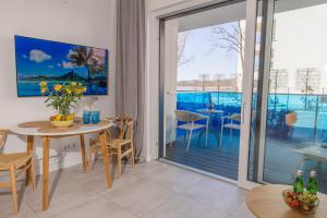 a dining room with a table and a sliding glass door at Apartamenty Boszkowo Aquarius Blue in Boszkowo