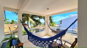 a hammock on a balcony with a view of the ocean at Home Beach in Maragogi