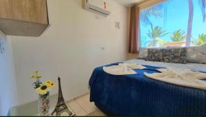 a bedroom with a blue bed with towels on it at Home Beach in Maragogi