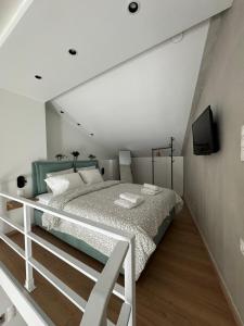 a bedroom with a bed and a tv on a wall at Arches House Kavala private Parking in Kavala