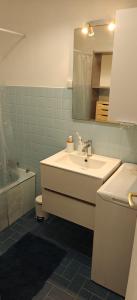 een badkamer met een wastafel, een toilet en een spiegel bij Appartement pieds dans l eau in Ajaccio