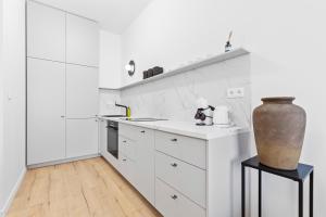 Una cocina con gabinetes blancos y un jarrón sobre una mesa. en LAM Serenity Free Parking - Balcony, en Bratislava