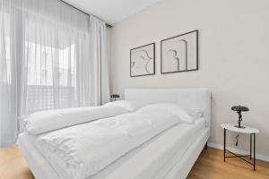 1 cama blanca en un dormitorio blanco con ventana en LAM Serenity Free Parking - Balcony, en Bratislava