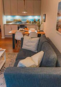 un soggiorno con un divano blu e una cucina di Ferienwohnung Sahel - Inselhof Fehmarn a Fehmarn