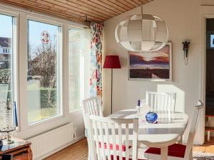a dining room with a table and chairs and windows at 4 star holiday home in SKÅNE VEJBYSTRAND in Vejbystrand