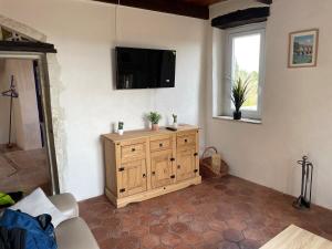 a living room with a tv on a wall at Maison de village atypique in Issirac