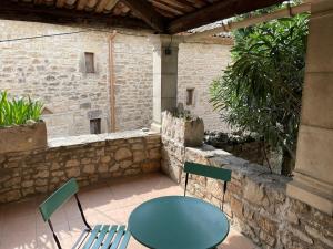 a patio with a table and chairs in a building at Maison de village atypique in Issirac