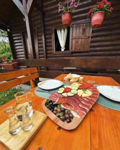 a wooden table with a plate of food on it at Cabin House Dubovik in Cetinje