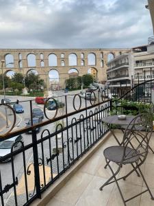 a balcony with a table and chairs and a building at Arches House Kavala private Parking in Kavala