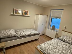 a bedroom with two beds and a window at Stylisches Landhaus Eifelgruß mit Top Lage, direkt am Wald und einzigartigem Naturgarten in Oberbettingen