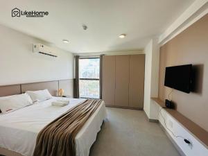 a bedroom with a large bed and a flat screen tv at Simple Smart em Manaíra - LikeHome Hospedagens in João Pessoa