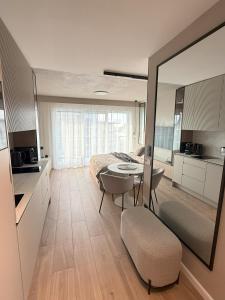 a bedroom with a bed and a table and a mirror at Apartment Magnolia Marina Lux & SPA in Dziwnów