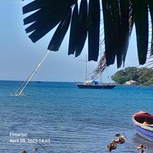 a sail boat in the water with a boat at Beach view tent in Port Antonio