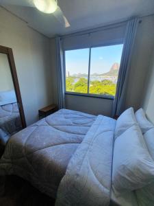 een slaapkamer met een bed en een groot raam bij Vista Mar - Pão de Açúcar 1 in Rio de Janeiro +20 foto's