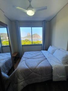 a bedroom with two beds and a large window at Vista Mar - Pão de Açúcar 1 in Rio de Janeiro