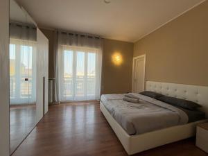 a bedroom with a large bed and large windows at SkyLoft Bergamo - Attico Chic con Panorama Unico in Bergamo +19 photos