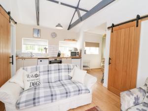 a living room with a white couch and a kitchen at Dinefwr Cottage in Carmarthen