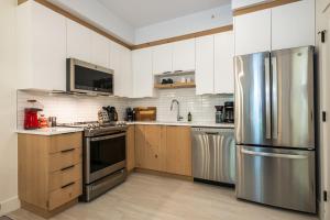 a kitchen with stainless steel appliances and wooden cabinets at Tremblant Prestige - Étoile 1500-2 in Mont-Tremblant +12 photos