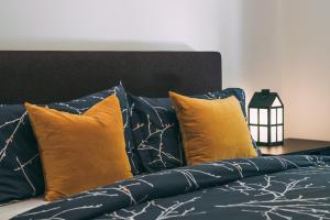 a bed with yellow and blue pillows on it at Tremblant Prestige - Étoile 1500-2 in Mont-Tremblant