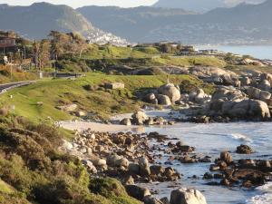 a river with a bunch of rocks in the water at Seaside haven in Simonʼs Town