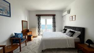 a bedroom with a bed and a window with the ocean at Avlakia Sunrise Haven Studios in Avlákia