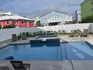 a swimming pool in a yard with chairs and houses at Swanky Seahorse in Carolina Beach