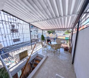 een balkon met een tafel en stoelen in een gebouw bij Hostal El Amanecer Costero in Santa Marta +12 foto's