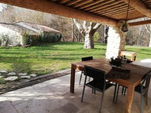 a wooden table and chairs on a patio at country house in Provence in Pierrevert