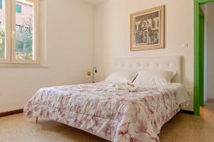 Un dormitorio con una cama grande con una colcha blanca. en Red House - view of the hills, en Terricciola