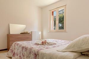 Un dormitorio blanco con una cama y una ventana. en Red House - view of the hills, en Terricciola