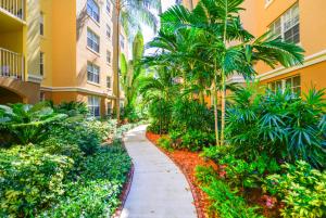 a walkway in front of a building with palm trees at Modern Luxury Condo Near Beach & Aventura Mall in Aventura