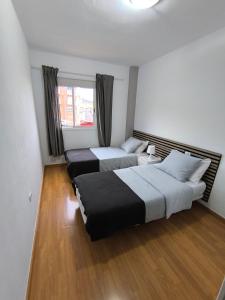 a bedroom with two beds and a window at BRISAS DEL MAR Eddy,,AIR,WIFI in Candelaria +8 photos