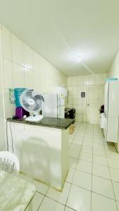 a kitchen with a refrigerator and a fan on a counter at Marcanau in Maracanaú