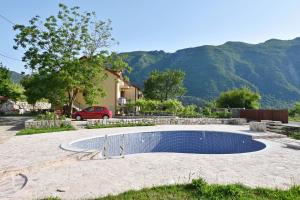 a swimming pool in a yard with a house and mountains at Apartments Pegaz in Virpazar