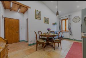 a dining room with a table and chairs and a clock at Casa Gavì -Bike Friendly- in Buonconvento
