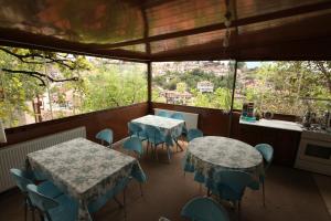 2 mesas y sillas en una habitación con ventana en Efe Guest House en Safranbolu