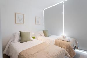 a bedroom with two beds with blankets and pillows at Located in the Best Area of Las Condes 2BR2BA in Santiago