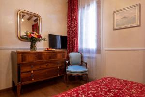 sypialnia z komodą, krzesłem i lustrem w obiekcie Residenza Santo Stefano w Wenecji