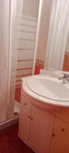 a bathroom with a white sink and a shower at Hostal Restaurante Bar Conrad in Abades