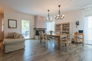 a dining room and living room with a table and chairs at Villa Matilde only 10 min from the beach in Novilara