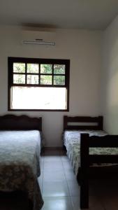 a room with three beds and a window at Chácara Pedacinho do Céu in Socorro +34 photos