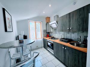 a kitchen with wooden cabinets and a table and a sink at Le Saint Georges - Bail Partner in Auxerre